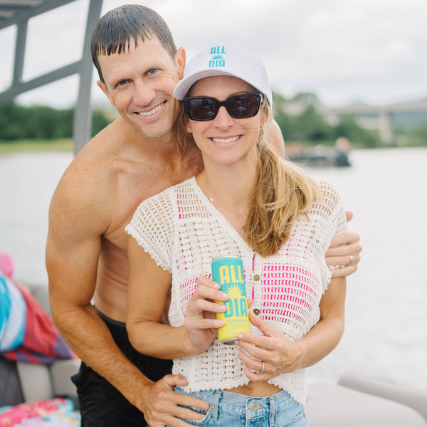 Man and woman on a boat holding 'All Day' drinks