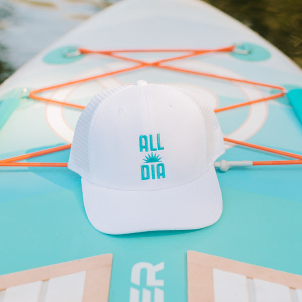 White cap with 'ALL DAY' text on a turquoise paddleboard